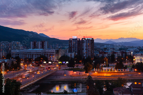 Elevated view of traffic on bridge passing over Vardar River with Skopje cityscape in background