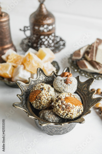 bowl with various pieces of Turkish delight and Oriental sweets on a light background photo