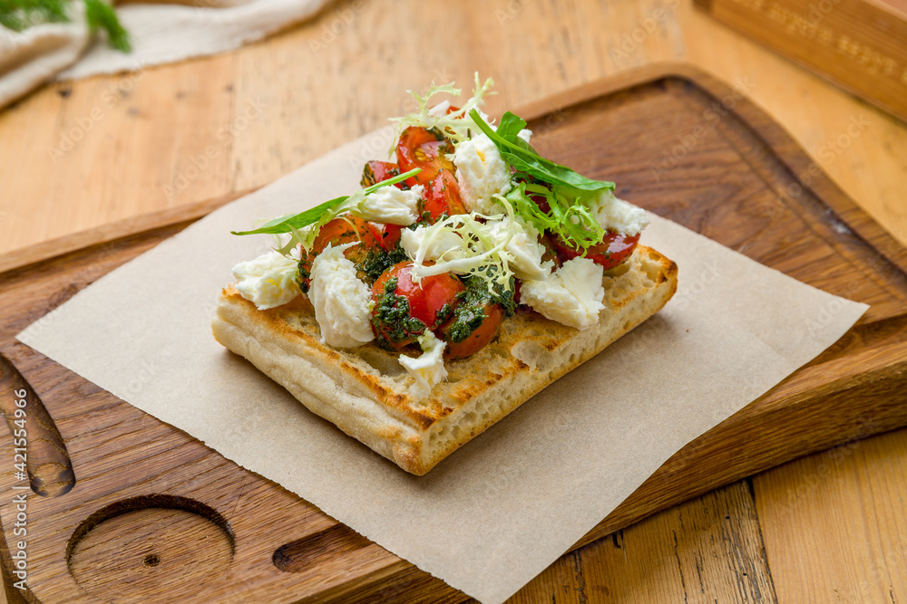 bruschetta with tomatoes, cheese and greenery on the board bruschetta with tomatoes, cheese and greenery on the board