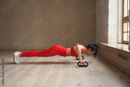 Woman training, doing plank at health club. Sporty attractive female working out