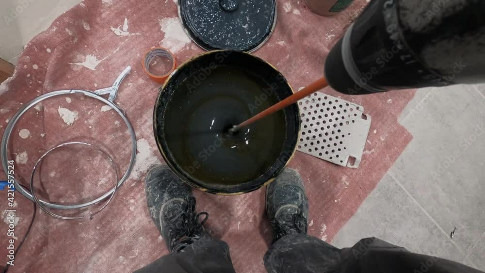 The Process Of Mixing black paint and hardener in a Bucket with a driller Stock ビデオ Adobe Stock