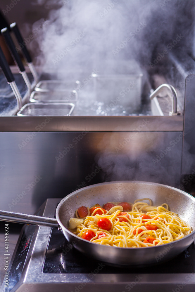 Cooking spaghetti concept. Pasta in the pan. Cooking Fresco Pasta. Italian cuisine, tomato sauce for pasta, healthy food making, detailed view steam in the kitchen. Flipping pasta in the air Cooking spaghetti concept. Pasta in the pan. Cooking Fresco Pasta. Italian cuisine, tomato sauce for pasta, healthy food making, detailed view steam in the kitchen. Flipping pasta in the air