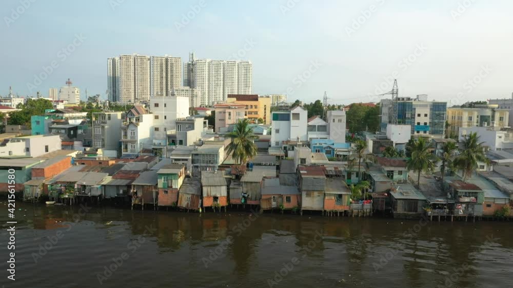 Classic drone shot with contrast of old and new buildings along the canal waterfront in district eight of Ho Chi Minh City, Vietnam. Camera tracks right in beautiful afternoon light. Classic drone shot with contrast of old and new buildings along the canal waterfront in district eight of Ho Chi Minh City, Vietnam. Camera tracks right in beautiful afternoon light.