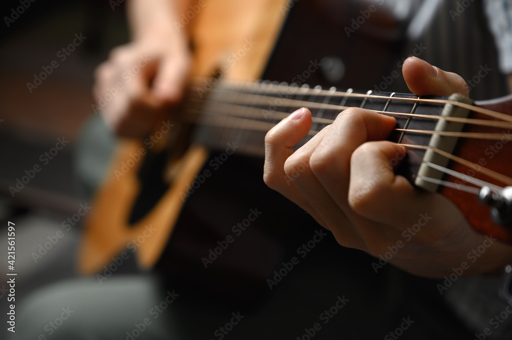 Man playing acoustic guitar, cover for online courses, learning at home.