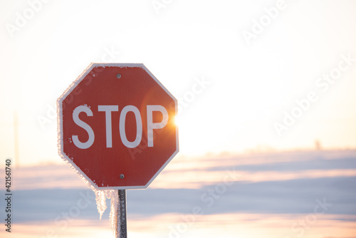 stop sign on a snow and sunny day
