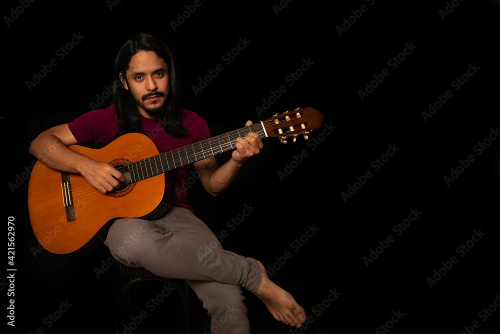 Obraz premium Man playing guitar with black background