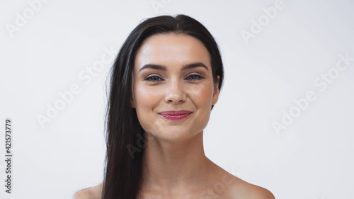 brunette woman with clean skin smiling at camera isolated on white