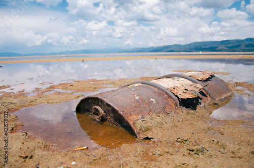 Rusted gas can stuck in the ground of dried up Lake photo