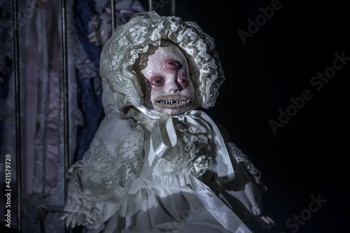 Scary dead doll with three eyes. Terrible monster. Scary portrait in the horror room.