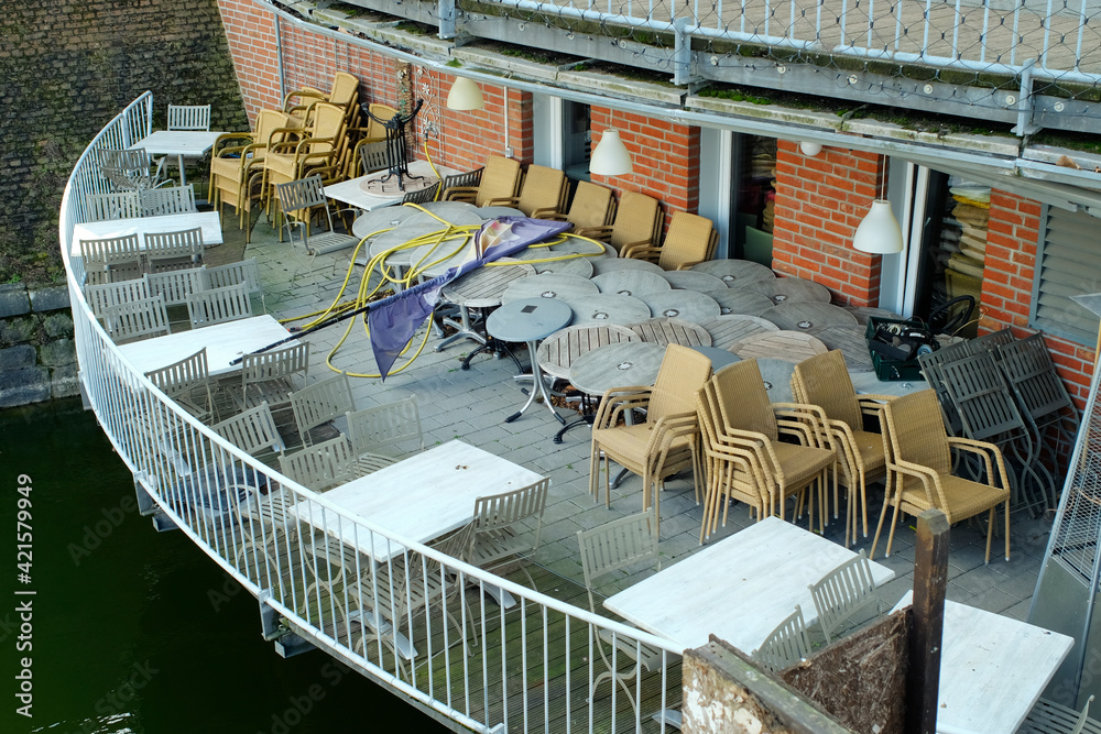 Gastronomy lockdown due to corona virus, closed reataurant, cafe or bar outdoor terrace with deserted tables and chairs