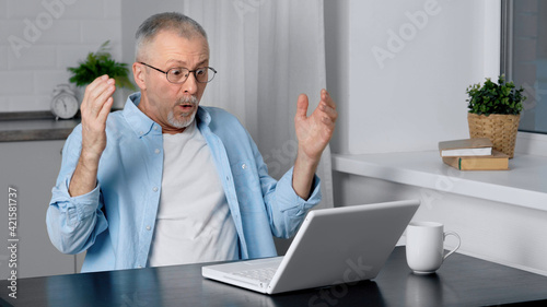 An elderly man with glasses is surprised by the news he saw on the Internet.