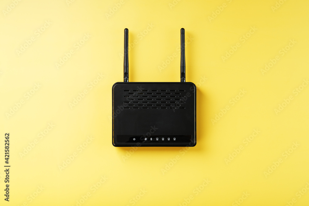 Black Wi-Fi router on a yellow background with free space. Black Wi-Fi router on a yellow background with free space.
