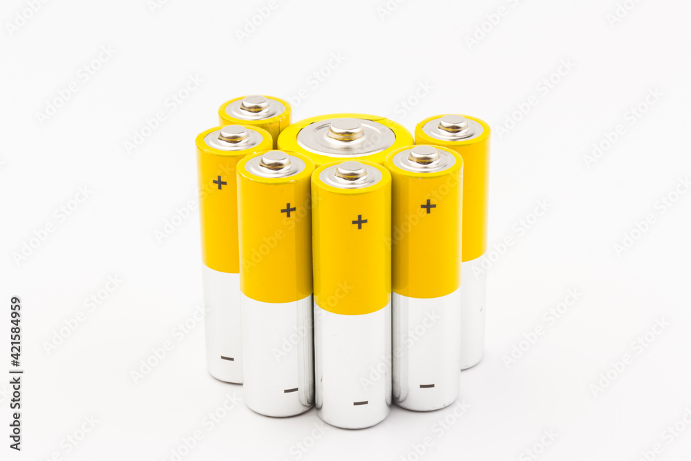 Photo of gray-yellow alkaline AA batteries on white background. Recycling of rechargeable NiMH batteries. The most popular size of accumulators. Copy space. Photo of gray-yellow alkaline AA batteries on white background. Recycling of rechargeable NiMH batteries. The most popular size of accumulators. Copy space.