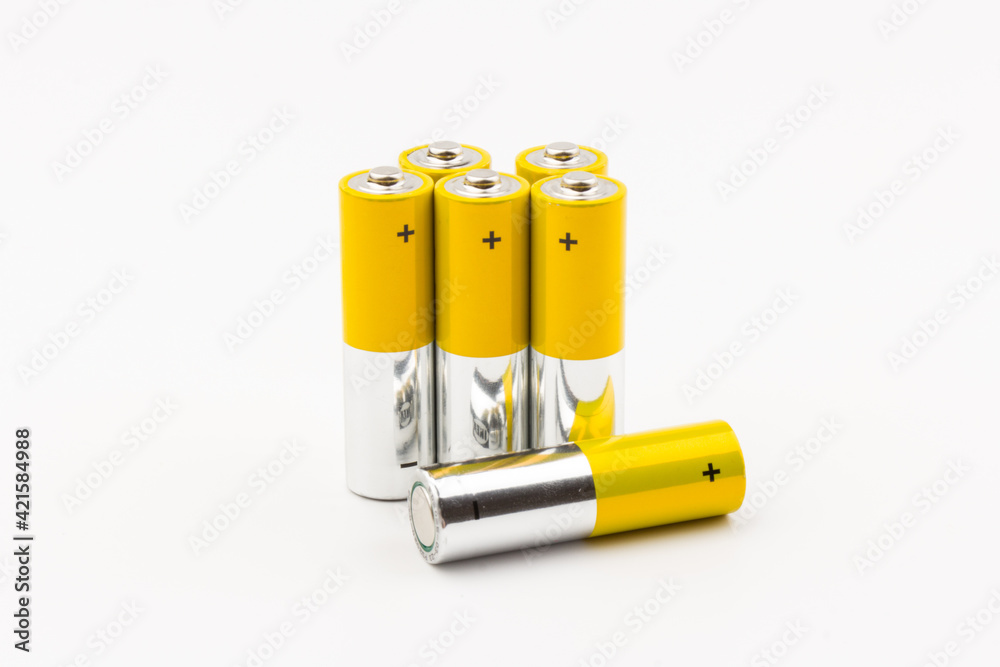Photo of gray-yellow alkaline AA batteries on white background. Recycling of rechargeable NiMH batteries. The most popular size of accumulators. Copy space. Photo of gray-yellow alkaline AA batteries on white background. Recycling of rechargeable NiMH batteries. The most popular size of accumulators. Copy space.