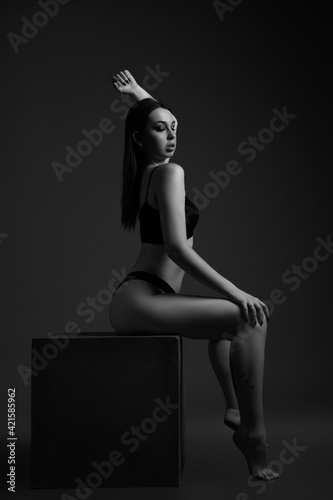 Black and white portrait of young beautiful woman with long hair and flawless figure.