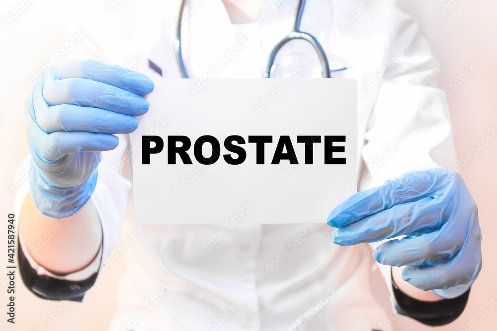 The doctor's blue - gloved hands show the word PROSTATE - . a gloved hand on a white background. Medical concept. the medicine The doctor's blue - gloved hands show the word PROSTATE - . a gloved hand on a white background. Medical concept. the medicine