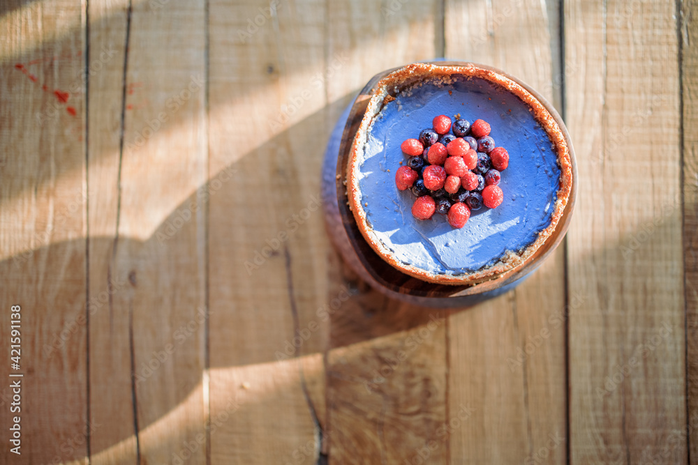 Cheesecake with berries on a wooden table, view from above Cheesecake with berries on a wooden table, view from above