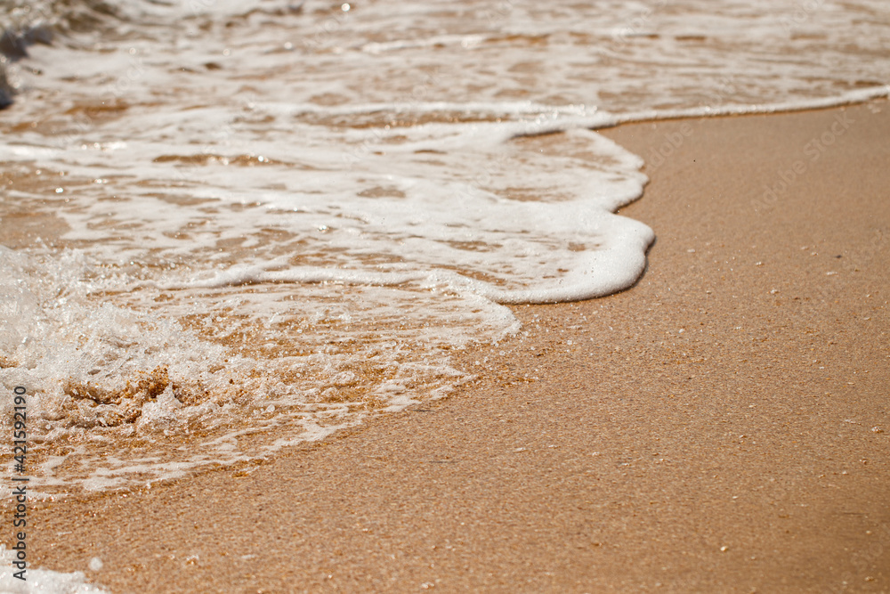 foaming sea wave on a sandy beach. Summer sea background
