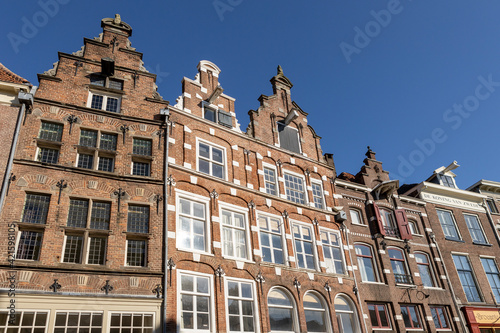 Looking up at typical historic medieval exterior facades in Hanseatic city center Zutphen, The Netherlands, against a clear blue sky. Europe tourism destination.