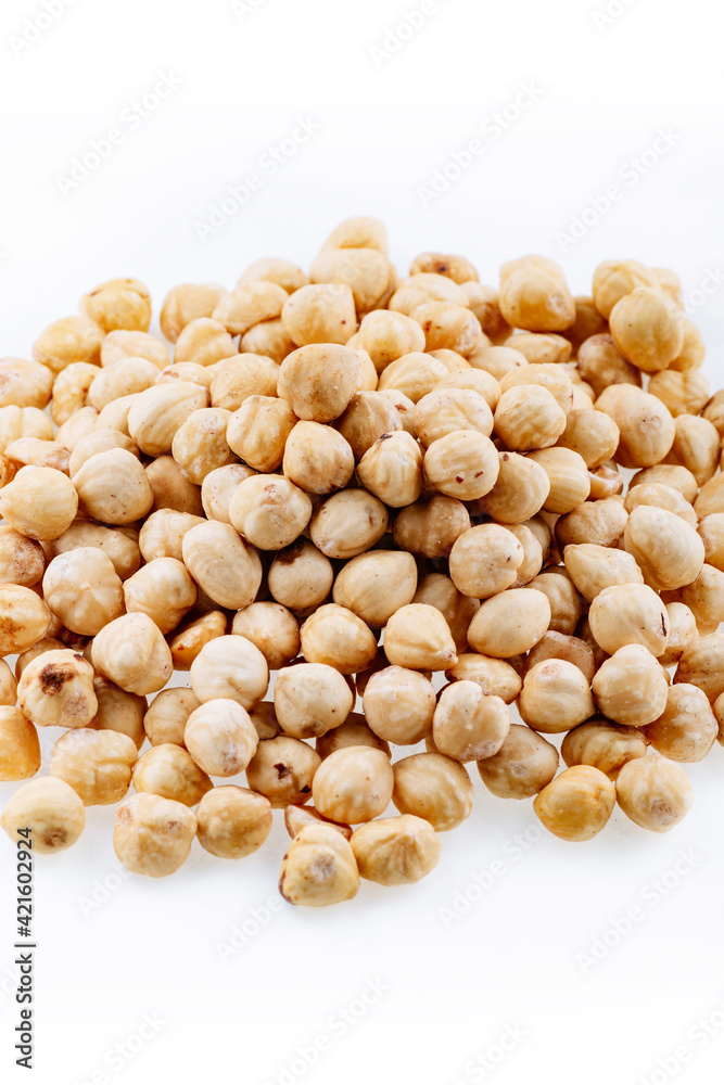 Roasted hazelnuts. A bunch of hazelnuts on a white background. Raw hazelnuts isolated over white background. Roasted hazelnuts background. Roasted hazelnuts. A bunch of hazelnuts on a white background. Raw hazelnuts isolated over white background. Roasted hazelnuts background.