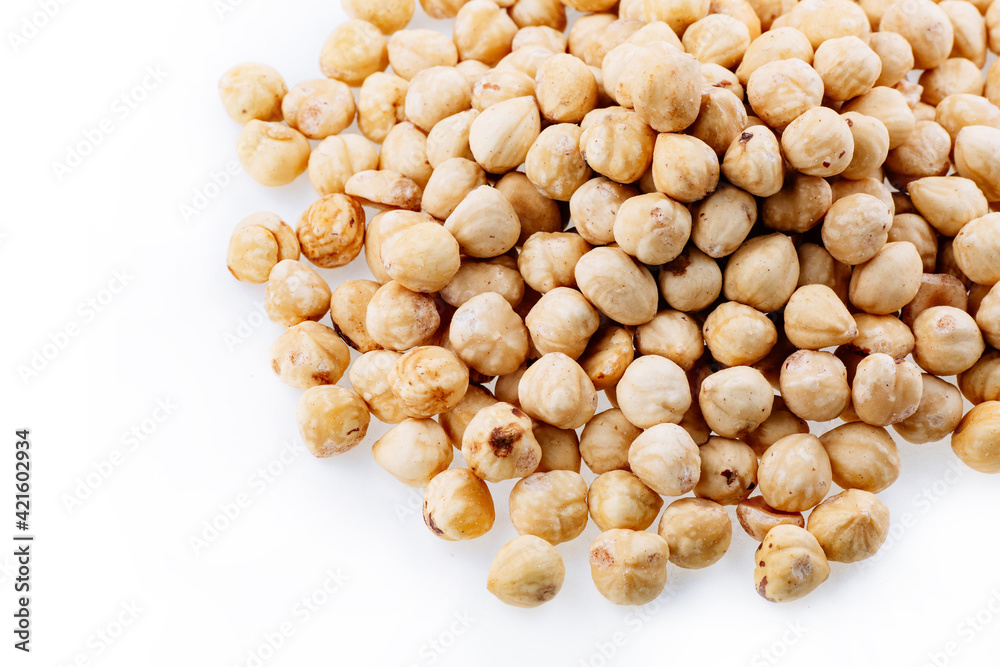 Roasted hazelnuts. A bunch of hazelnuts on a white background. Raw hazelnuts isolated over white background. Roasted hazelnuts background. Roasted hazelnuts. A bunch of hazelnuts on a white background. Raw hazelnuts isolated over white background. Roasted hazelnuts background.