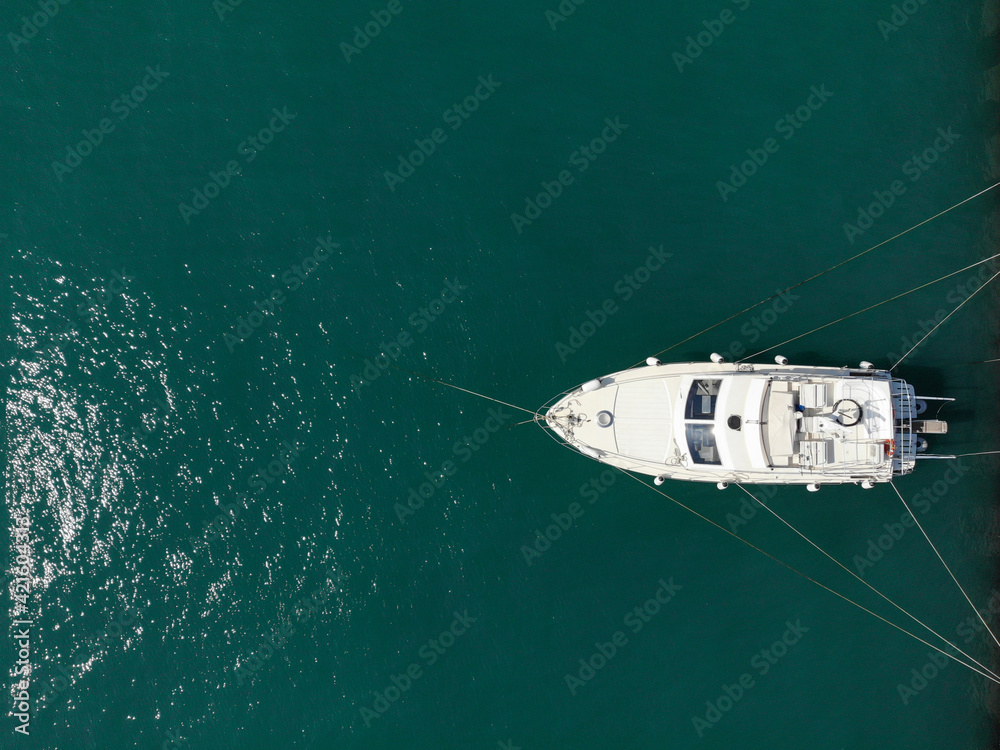 Aerial top view of white moored boat or yacht at dock, view from above. Copy space
