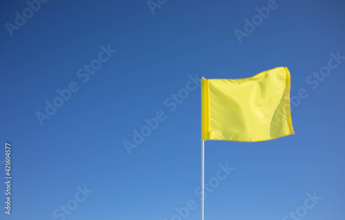 A yellow flag is waving in the wind