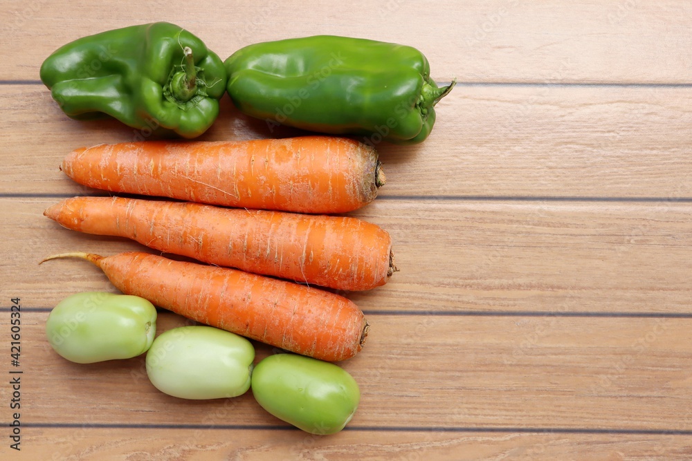 Vegetables on wooden background. Green bell peppers, carrots and green tomatoes. Organic food.
Vegetables on wooden background. Green bell peppers, carrots and green tomatoes. Organic food.