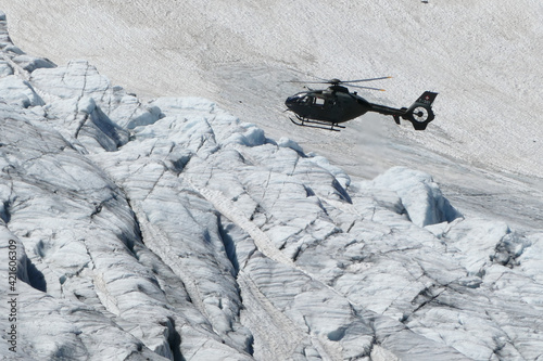 Swiss Airforce EC 635 Helicopter flying over a glacier photo