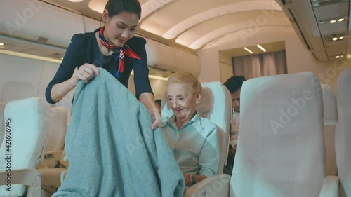 A beautiful woman cabin crew is smile greeting to passengers onboard , lifestyle and business travel concept