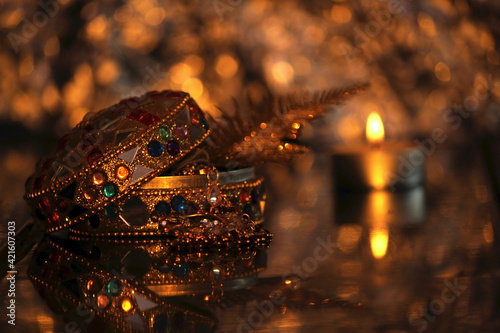 Golden box with gold and jewelry, blured candle. Luxury christmas decoration, happy new year 2022 and 2023,furtune telling and magic, warm cozy interior,  blured background
