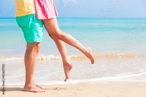 Leg view Of Couple Holding Hands On Beach Holiday