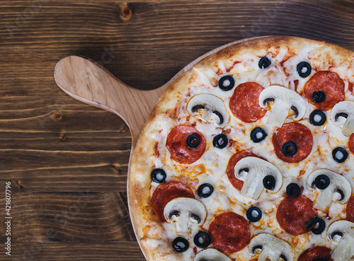 Pizza on the wooden background. Copy space. Place for text and design.