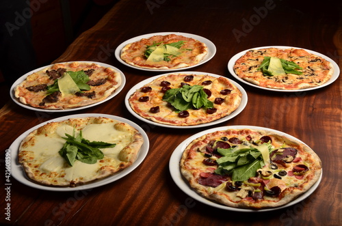 delicious pizzas on wooden table