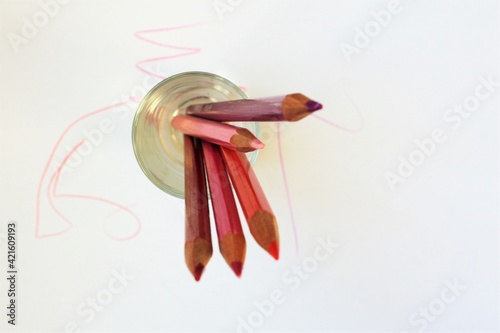 five colored pencils on the white background