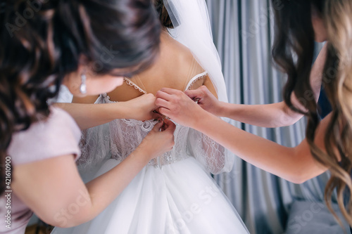 Wedding. bridesmaid prepares the bride for the wedding day. The girl helps to fasten a luxurious wedding dress before the ceremony. Best morning. Wedding concept.