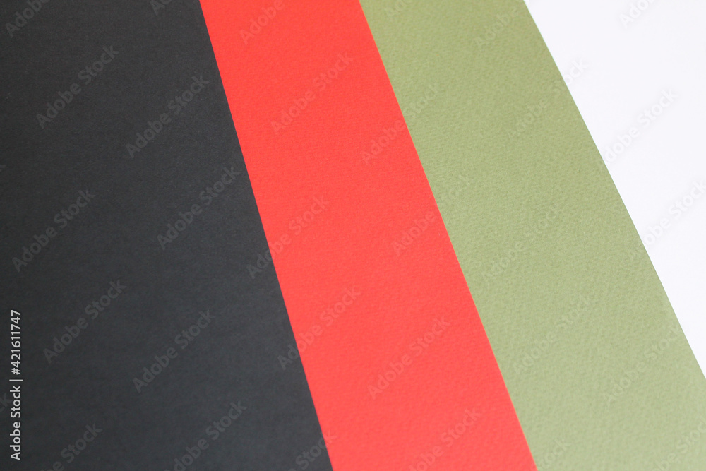 Four multi-colored Whatman paper is stacked on top of each other leaving oblique stripes. White, red, green and black Whatman paper. Close-up, top view. Office. Creation. Four multi-colored Whatman paper is stacked on top of each other leaving oblique stripes. White, red, green and black Whatman paper. Close-up, top view. Office. Creation.