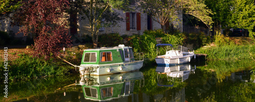 Panoramique deux bateaux sur la Sèvre Nortaise au soleil couchant à Damvix (85420), département de Vendée en région Pays de la Loire, France photo