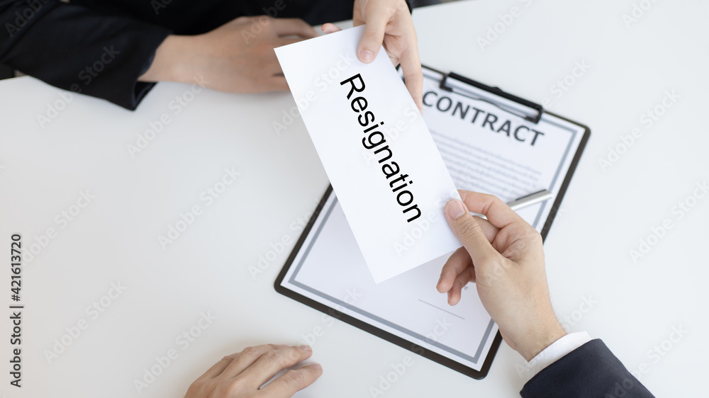Employee handed over a document envelope and a box of work equipment beside him, Woman submits resignation documents to their supervisor and take personal equipment in a brown box from the office. Employee handed over a document envelope and a box of work equipment beside him, Woman submits resignation documents to their supervisor and take personal equipment in a brown box from the office.