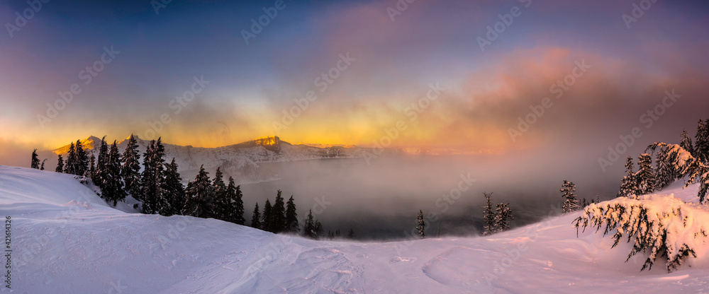 Crater Lake in Oregon at sunset hour in winter snow
