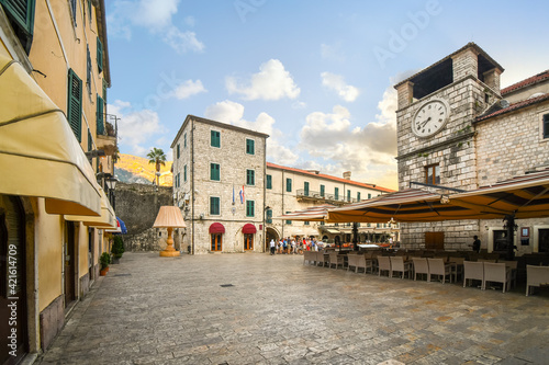 A tour group stands together early in the morning in the Square of the Arms in the medieval town of Kotor, Montenegro.
