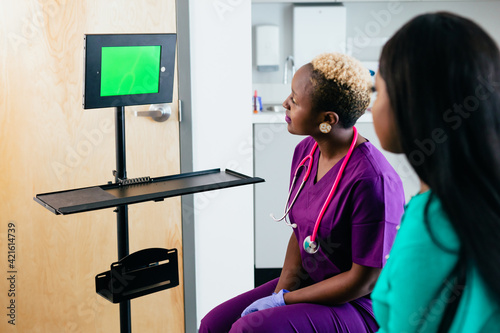 Black nurse and patient talks to virtual translator on video screen chat photo