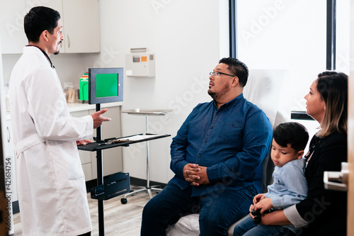 Doctor discussing results with hispanic family and virtual medical translator