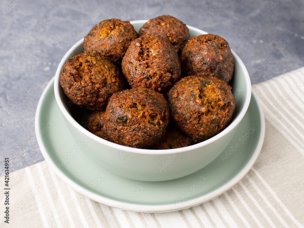 Fried vegan falafel in a mint bowl on a plate on a towel Fried vegan falafel in a mint bowl on a plate on a towel
