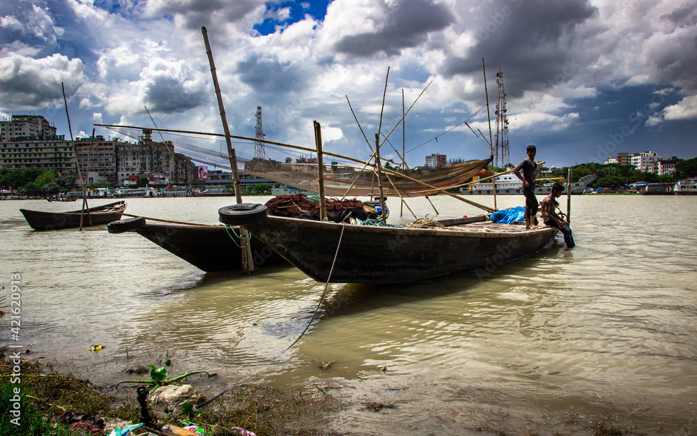 Boat and riverbank under the cloudy sky Boat and riverbank under the cloudy sky