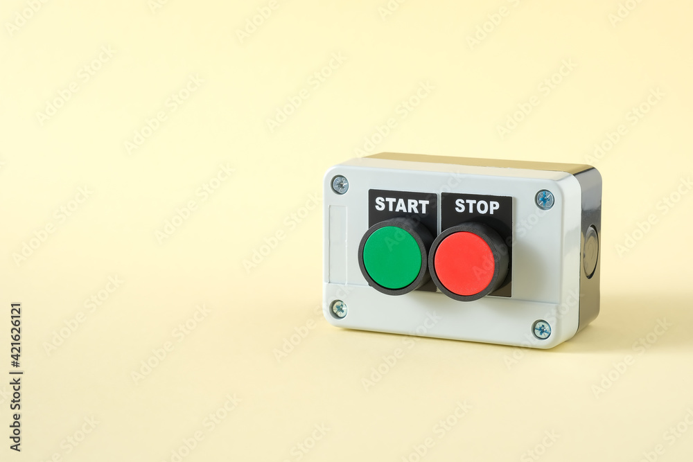Push button station with green start and red stop buttons on pastel background Push button station with green start and red stop buttons on pastel background