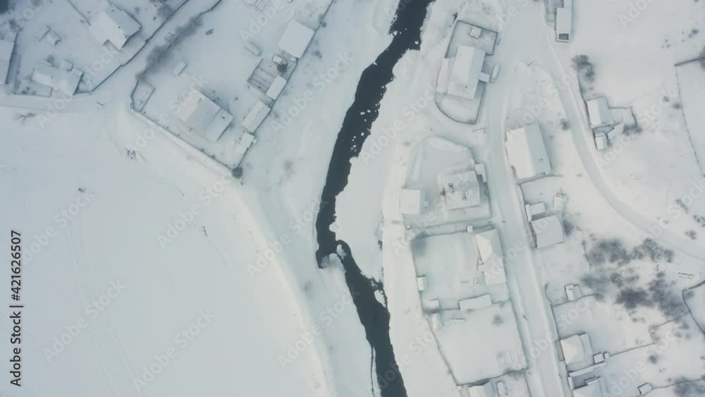 Aerial view of the river with ice in the middle of the village Aerial view of the river with ice in the middle of the village