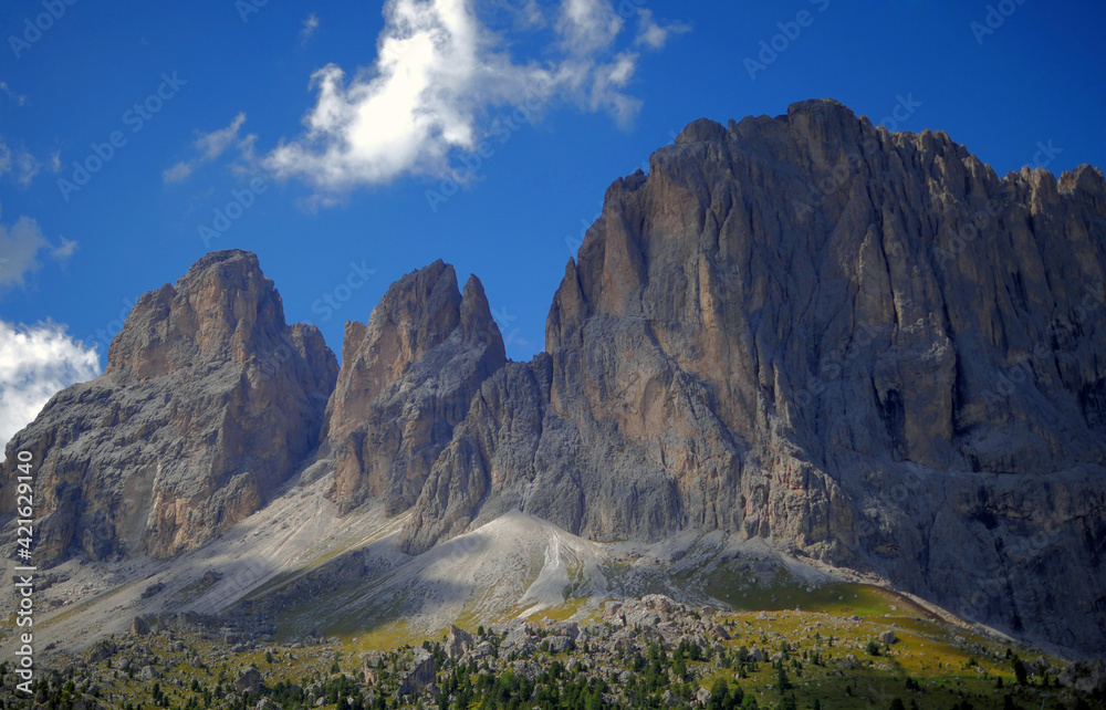 Large rocky mountains under a blue sky. Imposing mountains photographed from below. Panoramas of Trentino Alto Adige, Italy.
