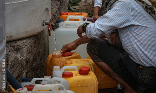  A Yemeni collects water due to the water crisis in the city of Taiz, Yemen