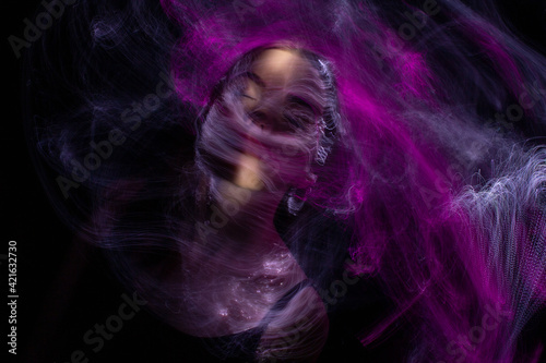 Fototapeta Naklejka Na Ścianę i Meble -  beautiful girl model with cosmic make-up on face, blue and purple color on dark background , longexposure foto
